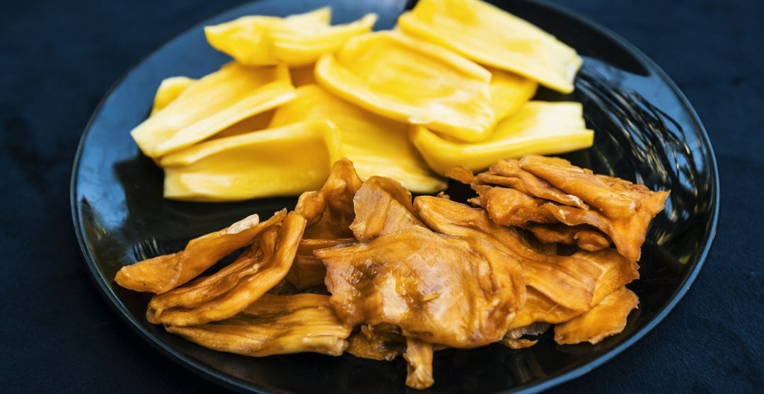 Close-up comparison of fresh jackfruit pieces and DoGood organic dried jackfruit slices served on a black plate